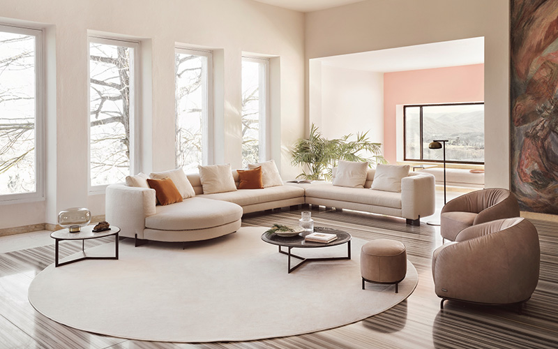 Luxury curved sofa in a bright, modern living room setup.