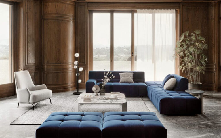 Modern blue sectional sofa in a luxury wood-paneled living room.