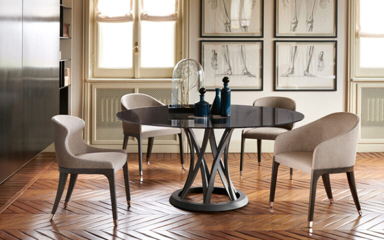Modern dining chair designs surrounding a round glass table.