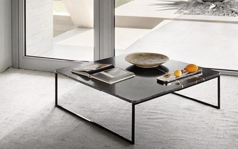 Black marble coffee table with books, fruit tray, and bowl