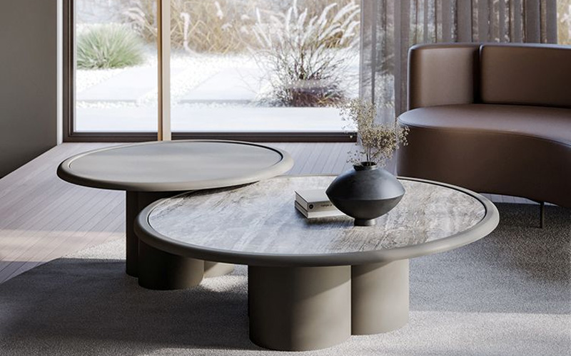 Marble coffee table with vase, book, and snowy window backdrop.