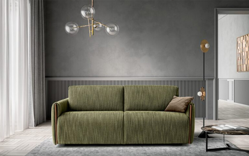 A textured green fabric sofa bed positioned in a contemporary interior