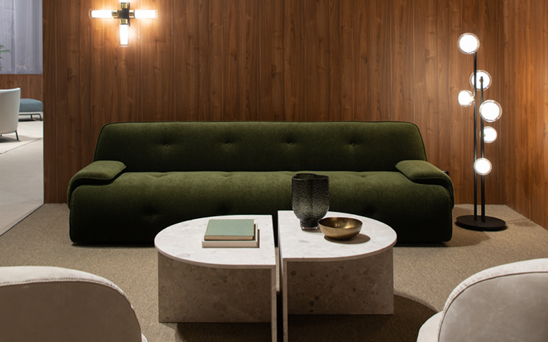 Green velvet sofa against wood panels creating rich interior textures.